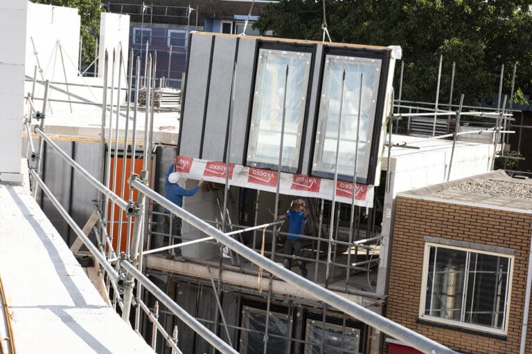 Magnesiumoxide gevelpaneel in aanbouw op een bouwplaats in Rotterdam met steigers en bouwelementen op de achtergrond